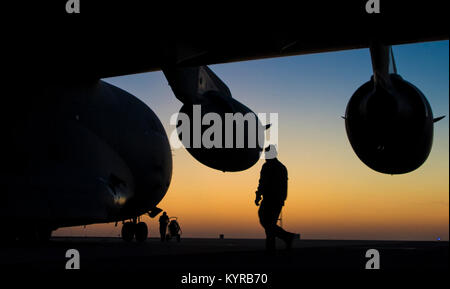 Ein US Air Force Crew Chief der Expeditionary 816th Airlift Squadron zugeordnet, kontrolliert eine C-17 Globemaster III nach einer Ladung Bewegung Mission am geheimen Ort, Vorderasien, Dez. 21, 2017. Die primäre Aufgabe der C-17 ist die schnelle strategische Bereitstellung von Truppen und verschiedene Arten von Ladung in Grundlagen der gesamten US Central Command sind der Verantwortung. (U.S. Air Force Stockfoto