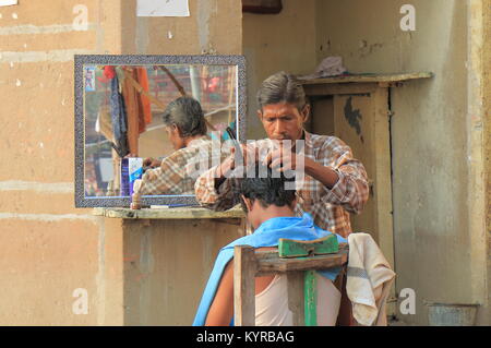 Unbekannter Mann arbeitet an der Straße Friseur in Varanasi Indien. Stockfoto