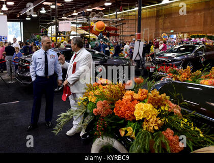 Us Air Force Chief Master Sgt. James Lyda, die 509Th Bomb Wing command Chief, spricht mit einem der Tournament of Roses Vertreter während einer Tour auf einem der Verzierung Orte in Pasadena, Calif., Dez. 30, 2017. Die Vertreter sind gemeinhin als "Weißen Suiten" für ihre charakteristische weiße Uniform bekannt, und sie sind dafür verantwortlich, dass jeder Aspekt der Rose Parade und Spiel reibungslos läuft. (U.S. Air Force Stockfoto