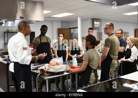 Sgt. 1. Klasse Raphael B. Bonair, Executive Adjutant, U.S. Army Norden (fünfte Armee) Studenten unterrichten über Messer Auslastung der neuen Lehre Küche in der Vogel Ausfallsicherheit. Der Vogel Ausfallsicherheit Center ist eine neue Anlage mit acht Einheiten von resiliency Services an einem Standort. Dieses Werk ist einzigartig in Fort Sam Houston und einzigartig in der Armee. Die Eröffnung der Vogel Ausfallsicherheit Center wurde am 5. Januar 2018. Stockfoto