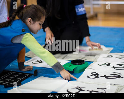 Ein Kind wählt ihr Liebling zeichnen Sie für die US-japanischen Joint Kalligraphie Ereignis gemacht, "Kakizome," an Waki Stadt, Japan, Jan. 6, 2018. Während des schreiben Teil der Veranstaltung Teilnehmer gemalte Wörter wie "Freund" und "Bond" als eine Möglichkeit, die beiden Kulturen aus der ganzen Welt zusammen. Sie erhielten auch Ihre bevorzugten Kalligraphie Malerei auf einer Wand, die mit jeder anwesend betrachtet werden. "Kakizome" ist eine Tradition der Japaner in jeweils zu Beginn des Jahres zu beteiligen, und es ähnelt, was in der westlichen Hemisphäre als Auflösung des neuen Jahres bekannt ist. (U.S. Marine Corps Stockfoto