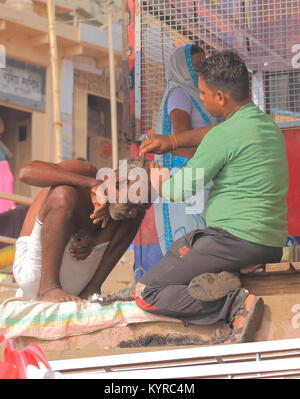 Unbekannter Mann arbeitet an der Straße Friseur in Varanasi Indien. Stockfoto