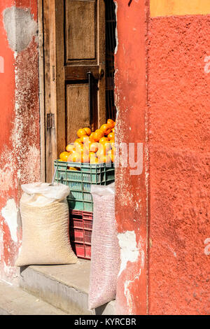 Faltschachtel mit frischen Orange und Taschen der Körner vor einem kleinen Lebensmittelgeschäft in San Miguel de Allende, Mexiko Stockfoto