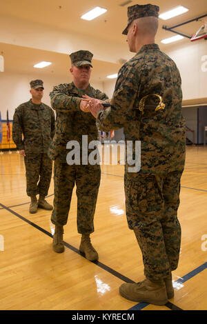 Us-Marines Corps Sgt. Maj. Dylan W. Goldman, Mitte, ging, Sergeant Major der Zentrale Regiment (HQ-Reg.), 2. Marine Logistics Group (MLG), II Marine Expeditionary Force (MEF), übergibt einen noncommissioned officer Schwert zu oberst Boyd Miller, A., kommandierender Offizier der HQ-Reg., 2. MLG, II MEF, während einer Post- und Überdruckventil Zeremonie in Camp Lejeune, N.C., Jan. 10, 2018. Während der Zeremonie, Goldman seinen Posten als Sergeant Major zu Sgt aufgegeben. Maj. Alex Narvaez. (U.S. Marine Corps Stockfoto