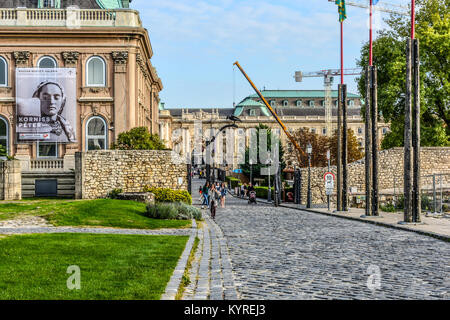 Das Budapest Geschichte und Kunst Museum mit einem Plakat für Fotografen Peter Korniss auf der äußeren als Touristen genießen die Budaer Burg Stockfoto