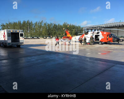 Coast Guard Besatzungsmitglieder an Bord eines MH-60 Jayhawk Helikopter von Air Station Clearwater, Florida, medevac ein 45 jähriger Mann Freitag, Januar 12, 2018 von Hochgeborenen Cay, Bahamas. Der Mann erlitt eine Verletzung zurück beim Segeln und wurde zu EMS Personal warten an Nassau, Bahamas transportiert. (U.S. Küstenwache Stockfoto