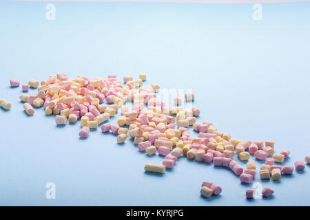 Bunte Marshmallows auf hellblauem Hintergrund mit Copyspace. Hintergrund oder Textur von bunten mini Marshmallows. Winter essen Hintergrund Konzept. Stockfoto
