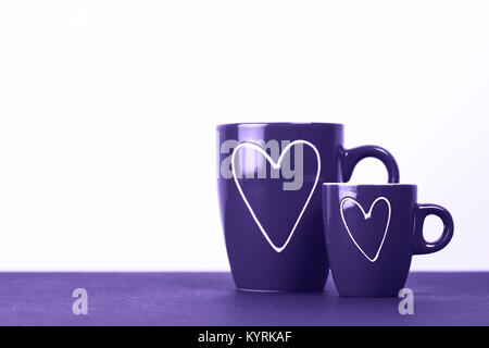 Zwei rote Tassen Tee oder Kaffee mit Herzen. Große und kleine - Mann und Frau. Liebe Konzept. Makro. Für Text platzieren. Stockfoto