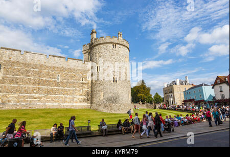 Blick auf Wände und den Turm von Schloss Windsor von der Stadt entfernt, an einem sonnigen Tag im Sommer mit einer Menge von Touristen am Straßenrand, Windsor, Berks, Großbritannien Stockfoto