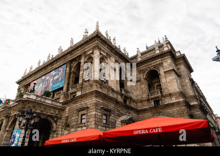Budapest, Ungarn - 13. August 2017: Low Angle View der Ungarischen Staatsoper in Budapest mit roten Sonnenschirmen im Vordergrund. Stockfoto
