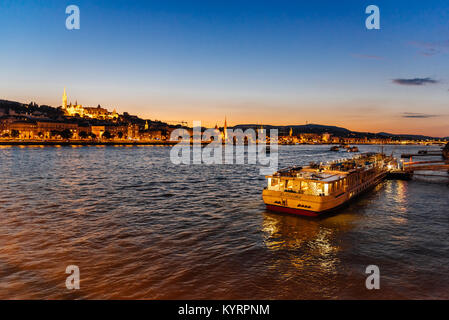 Budapest, Ungarn - 13. August 2017: Kreuzfahrtschiff für Touristen auf der Donau in Budapest günstig gegen die Budaer Burg bei Sonnenuntergang Stockfoto