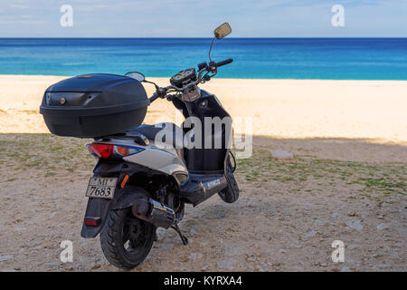 Motorroller geparkt auf den Strand von Myrtos. Scooter ist ein sehr beliebtes Transportmittel auf der Insel Kefalonia. Griechenland. Stockfoto