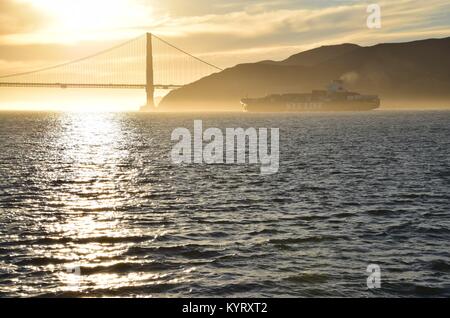 Containerschiff NYK Konstellation verläßt die Bucht von San Francisco unter der Golden Gate Bridge in den Sonnenuntergang.