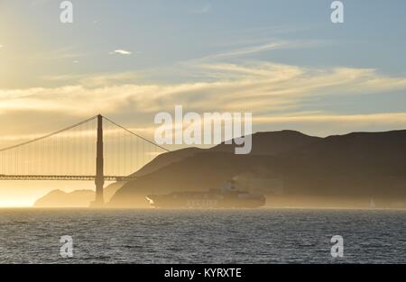 Containerschiff NYK Konstellation verläßt die Bucht von San Francisco unter der Golden Gate Bridge in den Sonnenuntergang.