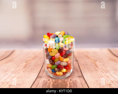 Bunte Jelly Beans in einem Glas auf einem hölzernen Hintergrund Stockfoto