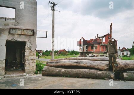 Sunja (moslavina) in Kroatien: Während des Krieges 1991 - 1995 wurde das Dorf fast von den serbischen Truppen umgeben, und nur per Fähre über den Fluss Sava zugänglich. Zerstörte Gebäude, Barrikaden aus Holz und eine symbolische Galgen mit der Puppe von einer serbischen Soldaten ('Chetnik') an der Frontlinie zwischen der Republik Kroatien und der Republik Serbische Krajina. Das Bild wurde im Juni 1992. Stockfoto