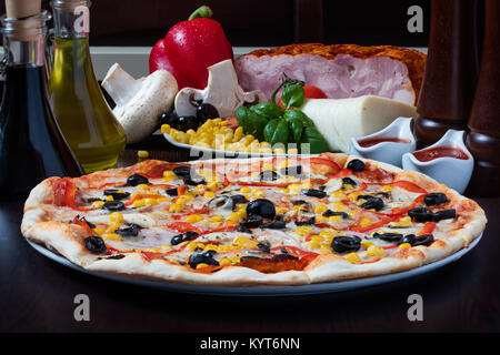 Pizza mit Oliven Mais und Paprika Stockfoto