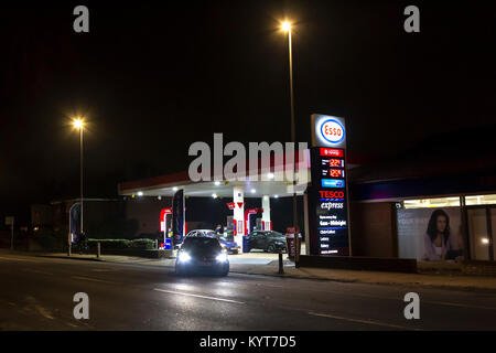 Die Esso-tankstelle und Tesco Express auf Wellingborough rd auf einem dunklen Winter Abend. Northampton, Stockfoto