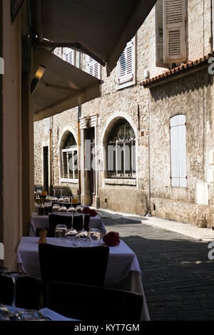 Gemütliches Restaurant Tabellen auf dem alten gewundenen Straße in einer kleinen europäischen Stadt Nizza in Frankreich, von Touristen besucht, die von der historischen Vergangenheit angezogen Stockfoto