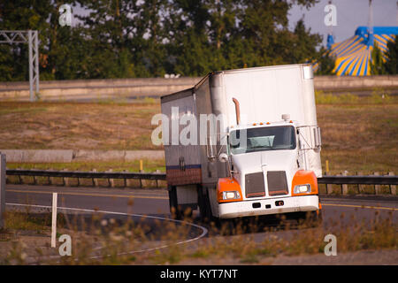 Ein weißes amerikanisches leistungsstarke Professional Day Cab Big Rig Semi Truck mit zwei trockenen van Sattelauflieger im Auto Zug dreht an der Autobahn Eingang Stockfoto