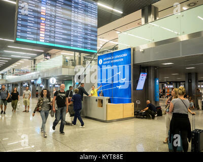 Krakau, Polen - Juni 6, 2017: Informationen Schreibtisch, Passagiere und eine Frau zeigt die Richtung, die Sie am Internationalen Flughafen in Balice, Krakau, Polen Stockfoto