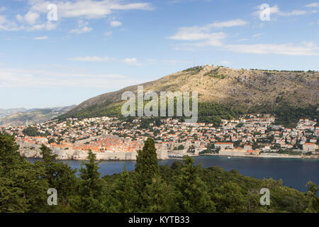 Gebäude auf dem Hügel und Berg Srd in Dubrovnik, Kroatien, gesehen von der grünen Insel Lokrum an einem sonnigen Tag. Kopieren Sie Platz. Stockfoto