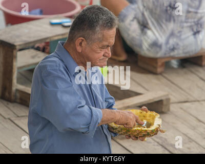 Caballococha, Peru - Dec 11, 2017: Porträt eines Mannes essen Ananas vom Löffel. Stockfoto