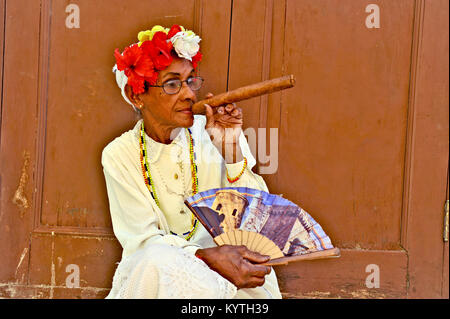 Havanna, Kuba, 6. Mai 2009. Eine alte Frau sitzt mit einem riesigen Zigarre in den Mund und Rosen in ihren Kopf in Havanna, Kuba, am 7. Mai 2009. Stockfoto