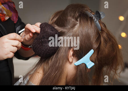 Weibliche Hände braid dunklen Haar, close-up. Stockfoto