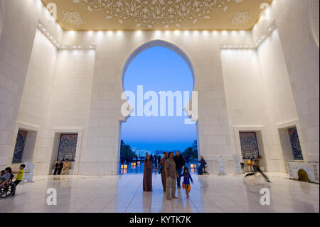ABU DHABI, VEREINIGTE ARABISCHE EMIRATE - Dez 31, 2017: Die haupthalle und Eingang der Sheikh Zayed Moschee in Abu Dhabi in der Dämmerung. Es ist die größte mosq Stockfoto