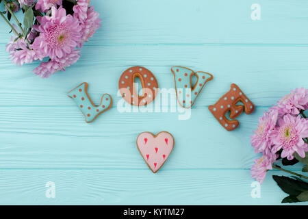 Schreiben von Cookies für Valentinstag. Valentinstag Blumen und Ingwer cookies Dekoration. Schönen Gruß Komposition. Stockfoto