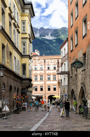 Strasse in der Altstadt von Innsbruck Österreich im sonnigen Sommertag. Im Hintergrund über die Dächer der Häuser, grüne Berge, die von der Sonne beleuchtet. Stockfoto