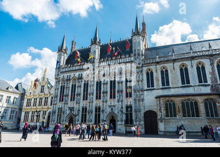 Brügge, Belgien, 31. August 2017: architektonisches Ensemble in der Burg Marktplatz mit dem Rathaus und dem Alten Standesamt (Fietskoetsen) und Mitarbeiter Stockfoto