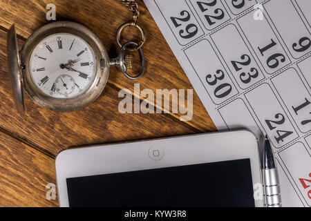 Tablet PC, Pen, Kalender und Antik Silber Taschenuhr auf hölzernen Hintergrund Stockfoto