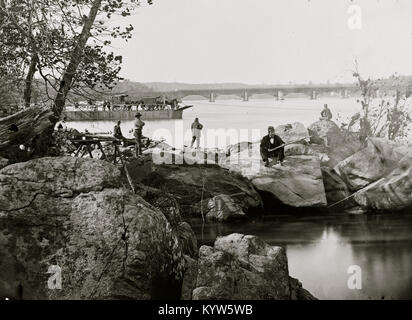 Washington, D.C. Georgetown Fähre mit Wagen und Aquäduktbrücke jenseits, von Felsen auf Mason's Island Stockfoto