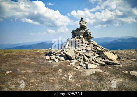 Steinwuerdigkeit auf Berg gegen den blauen Himmel mit Wolken. Damm auf Höhe, in der Wüste. Commemorative dolmen für Reisende im malerischen Ort. Pic Stockfoto