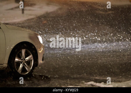 Newtownabbey, Nordirland, Irland. 16 Jan, 2018. Auto durchdrehende Räder während amber Wetter Warnung fahren als starker Schneefall beginnt Newtownabbey zu decken außerhalb Belfast, Nordirland, 16. Januar 2018 Credit: Radharc Images/Alamy leben Nachrichten Stockfoto