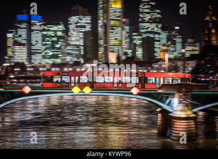 Frankfurt am Main, Deutschland. 16 Jan, 2018. Eine rote Straßenbahn kreuzt den Main und die Skyline bei Nacht in Frankfurt am Main, Deutschland, 16. Januar 2018. Foto: Frank Rumpenhorst/dpa/Alamy leben Nachrichten Stockfoto