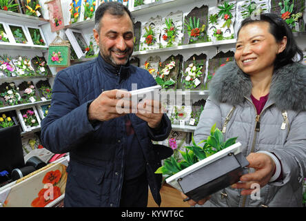 (180117) - Hangzhou, Jan. 17, 2018 (Xinhua) - eine irakische Händler nimmt Fotos von künstlichen Pflanzen bei einem internationalen Shopping Mall in Wuhan, der ostchinesischen Provinz Zhejiang, Dez. 23, 2017. Nach Hangzhou, Zhejiang's Foreign Trade Wert belief sich auf 2,56 Billionen Yuan (rund 397.6 Mrd. US-Dollar) im Jahr 2017, um 15,3 Prozent mehr als im Vorjahr. Die Exporte und Importe wuchsen um 10,1 Prozent und 35,6 Prozent über Vorjahr. (Xinhua/Tan-Jin) (mcg) Stockfoto