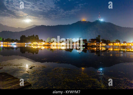 Dal Lake (Golden Lake) auf Srinagar, Indien als auf einem Vollmond Nacht mit Haus Boote gesehen beleuchtet. Tempel Shankaracharya oben auf den Hügeln gesehen. Wunder Stockfoto