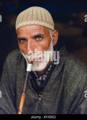 Sonamarg, Jammu und Kaschmir - 11. August 2017: Eine alte traditionelle muslimische Kaschmir Mann raucht Shisha / Wasserpfeife bei thajiwas Gletscher für Erholung. Stockfoto