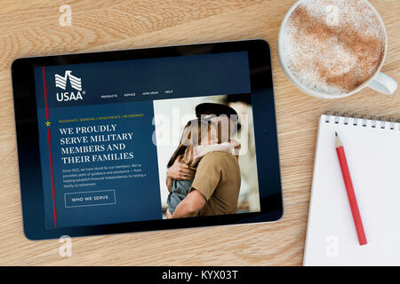 Die United Services Automobile Association (Usaa) Website auf einem iPad Tablet, auf einem Holztisch und Notizblock, Bleistift und Tasse Kaffee (nur redaktionell). Stockfoto