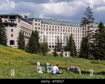 Paar mit Hunden in der Nähe von Chateau Lake Louise, Lake Louise, Banff National Park, Alberta, Kanada. Stockfoto