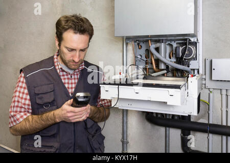 Klempner Instandsetzung ein Brennwertkessel Stockfoto