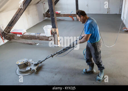 Arbeiter polieren Sand und Zement Estrich Boden. Stockfoto