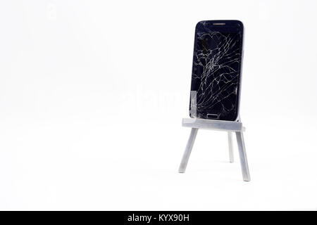 Ein Handy mit dem Display gebrochen/verkratzt. Insgesamt weißen Hintergrund. Stockfoto