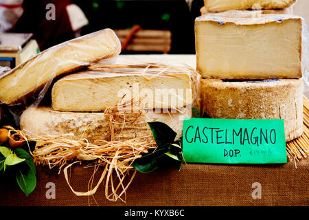 Italienische Käse-Display in einem Bauernmarkt in Piemont. Castelmagno Käsebrote am Marktstand. Nahaufnahme, Gourmet-Käse in loser Schüttung. Stockfoto