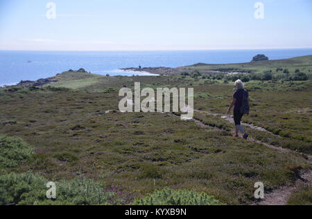 Einsame Dame Wanderer gehen hinunter Kitten Hill auf der Insel Gugh, die hl. Agnes, die Scilly Inseln, England, Cornwall, UK. Stockfoto