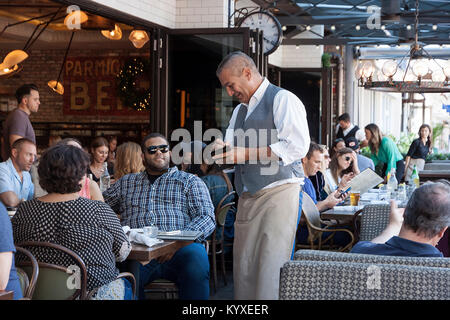 Kellner unter Kundenauftrag auf einem Notizblock in einem Restaurant. Stockfoto