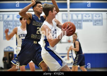 Während der Fahrt auf der Grundlinie ein Spieler eine Naht an den Hoop versucht hat, während der Ball zum Schutz von einem Verteidiger bei einem High School Spiel. USA. Stockfoto